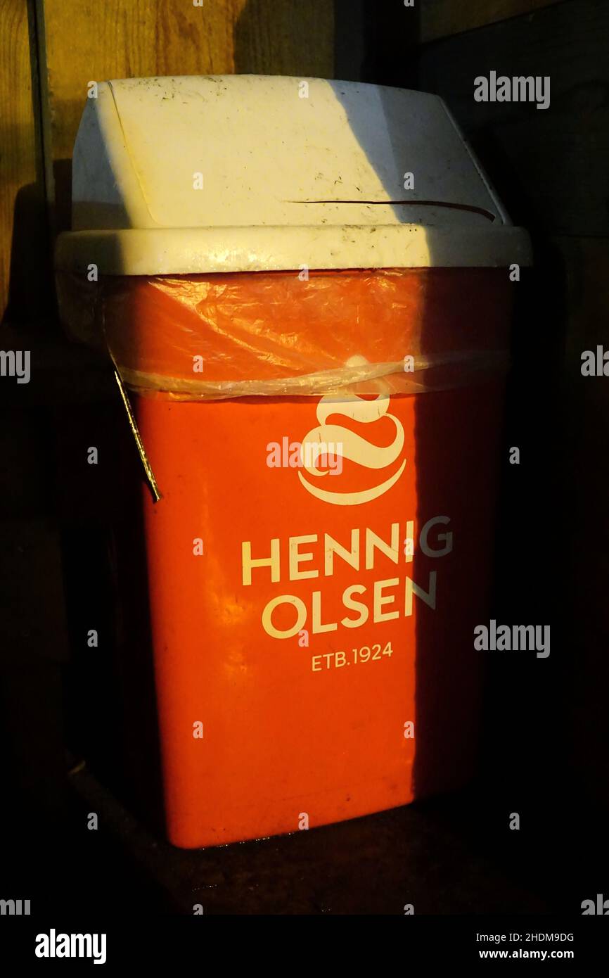 Orange and white trash can, waste bin with logo on from norwegian ice-cream maker Hennig-Olsen. Stock Photo