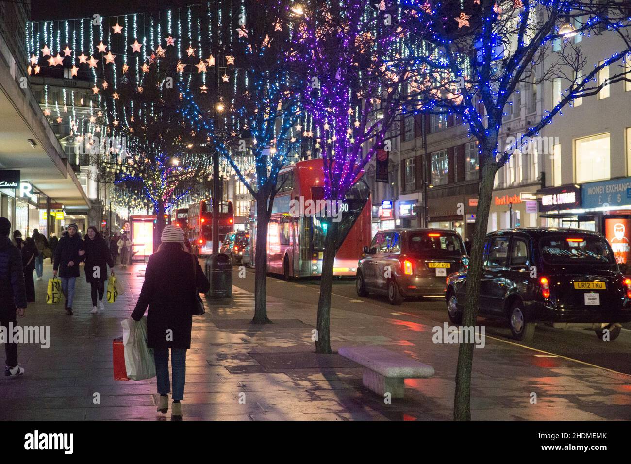 London, UK, 6 January 2022: early evening shoppers on Oxford Street as the January sales continue. Footfall is sharply down from pre-pandemic levels but shops are open and customers are obliged to wear face masks under the Plan B regulations which are in place. Anna Watson/Alamy Live News Stock Photo