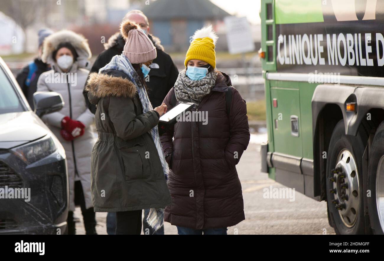 Toronto, Canada. 6th Jan, 2022. A staff member registers for people outside a mobile COVID-19 vaccination clinic in Toronto, Ontario, Canada, on Jan. 6, 2022. Canada's cumulative COVID-19 cases surpassed 2,400,000 as of Thursday morning, with the total hitting 2,408,013, including 30,544 deaths, according to CTV. Credit: Zou Zheng/Xinhua/Alamy Live News Stock Photo