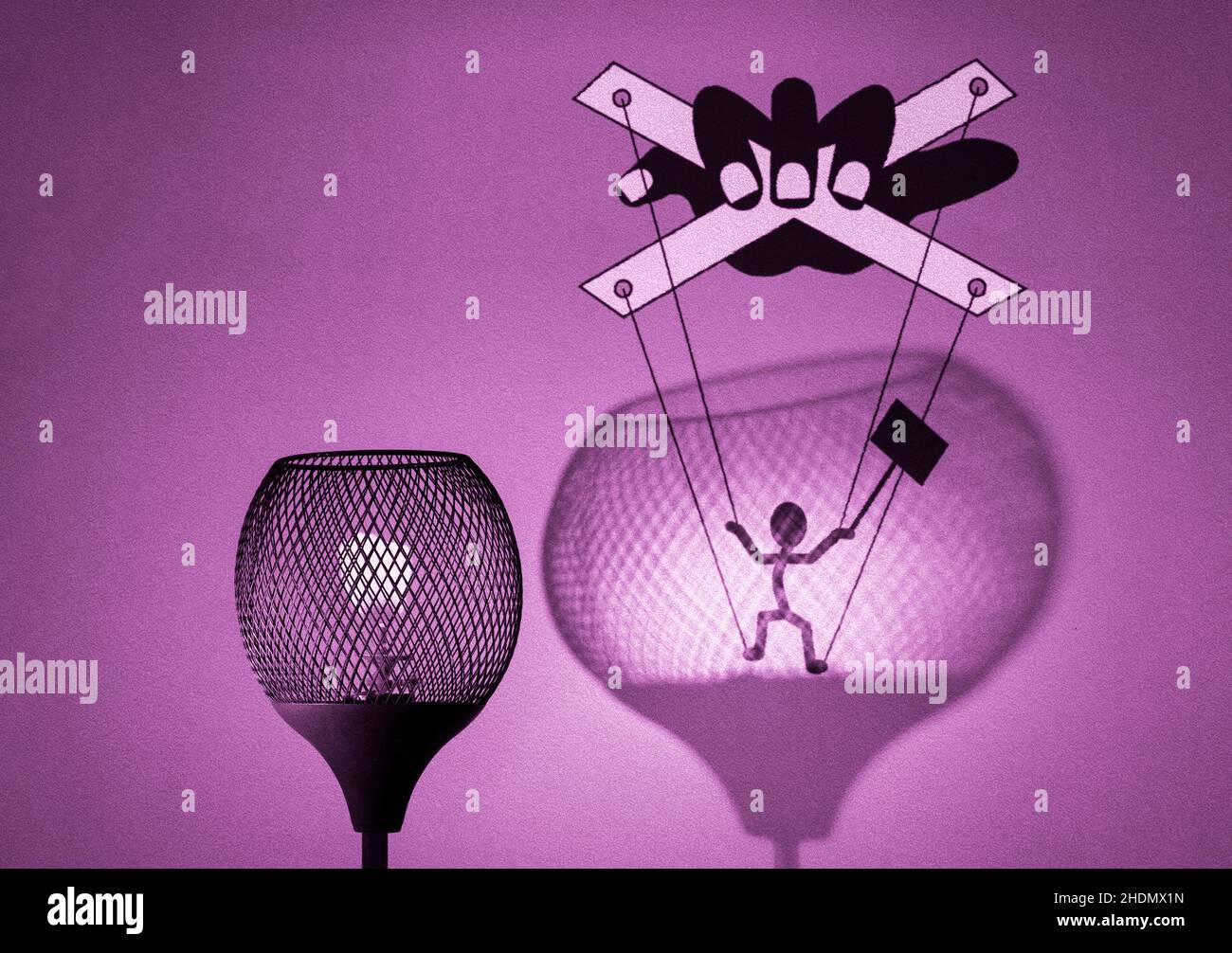 Gaslight with silhouette of puppet on strings being manipulated by a hand in shadow cast by the lamp on wall gaslighting concept illustration Stock Photo