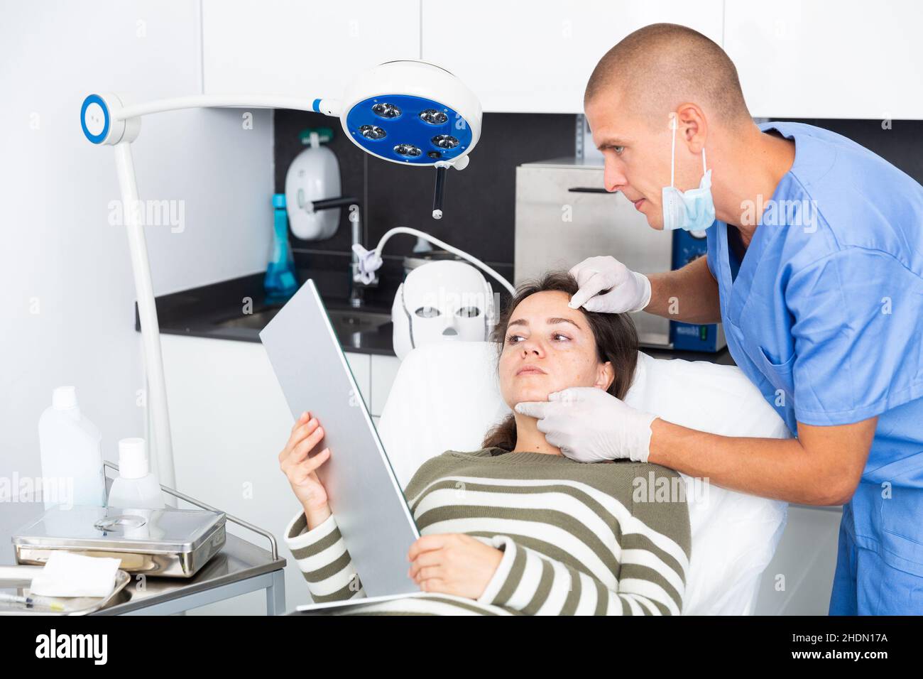 Cosmetician explaining hardware facial procedure to female client Stock ...