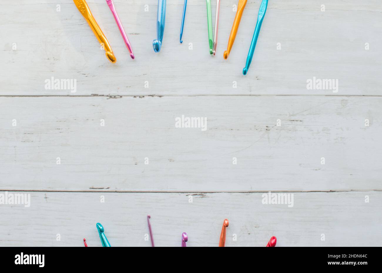 Colorful crochet hooks on a wooden background Stock Photo