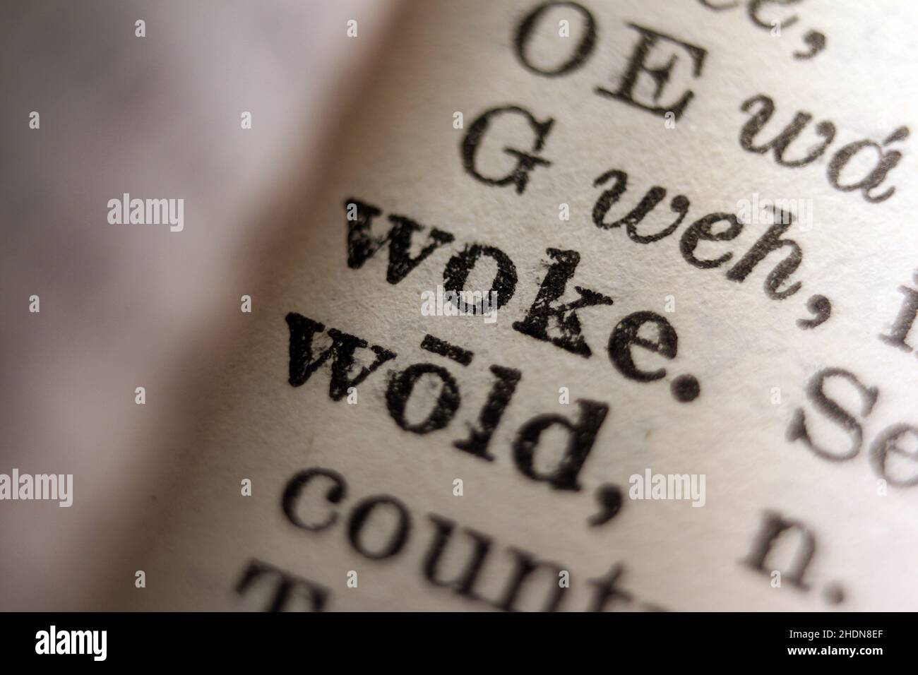 Word 'woke' printed on dictionary page, macro close-up Stock Photo