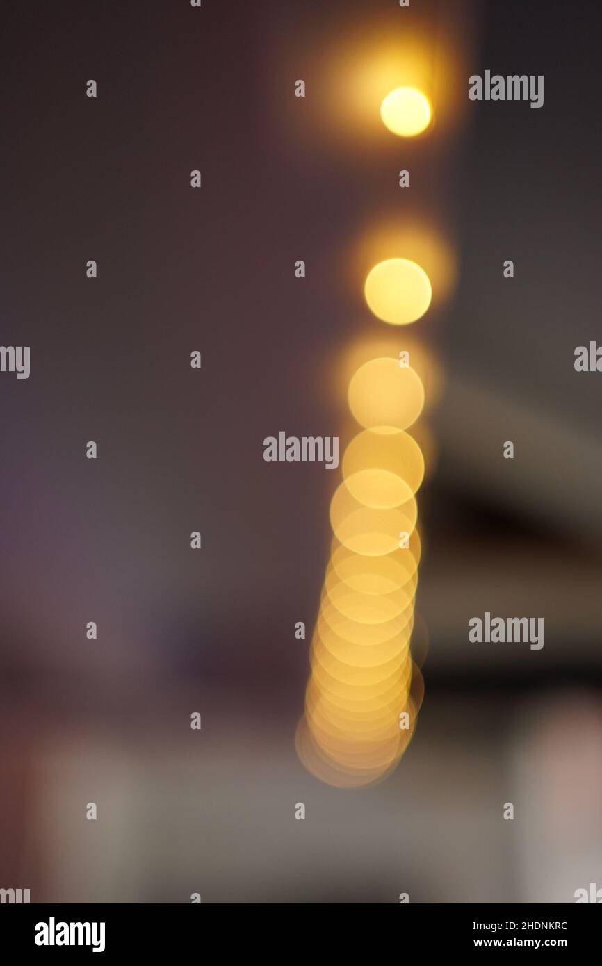 Closeup of the glowing yellow bokeh lights on the blurry background Stock Photo