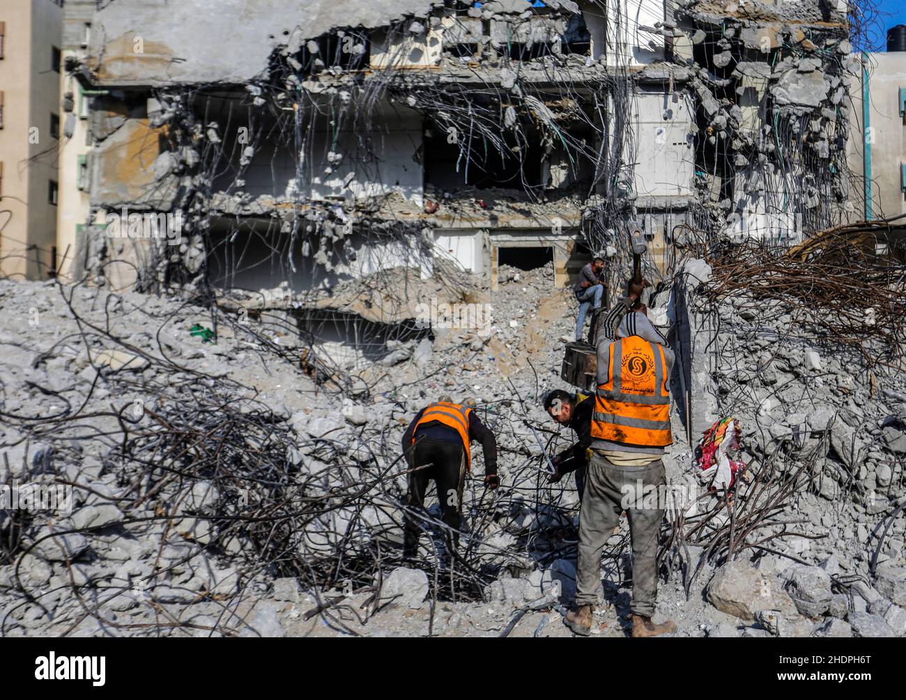 Palestinian workers remove the rubble with a bulldozer from Al-Jawharah ...