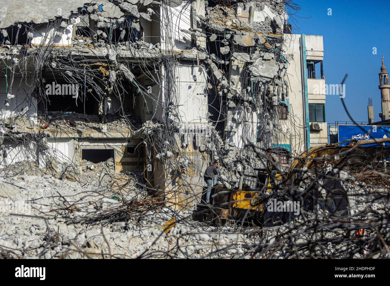 Palestinian workers remove the rubble with a bulldozer from Al-Jawharah ...