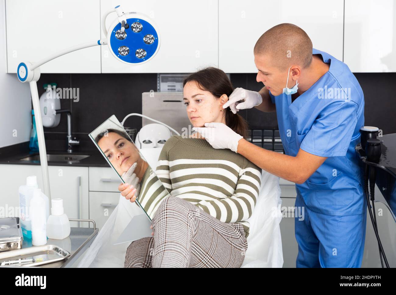 Cosmetician explaining hardware facial procedure to female client Stock ...