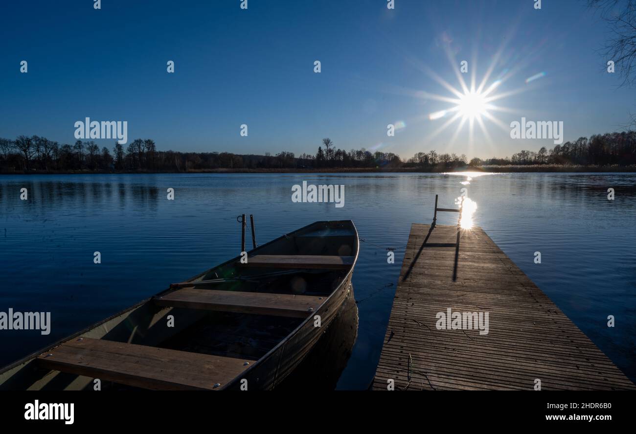 Beeskow, Germany. 06th Jan, 2022. A boat moors at a wooden jetty on Lake Bahrensdorf in bright
