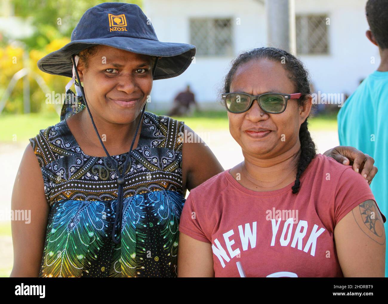 Two Melanesian women smiling as their picture is being taken in March 2021 at Madang Aiport in Papua New Guinea Stock Photo