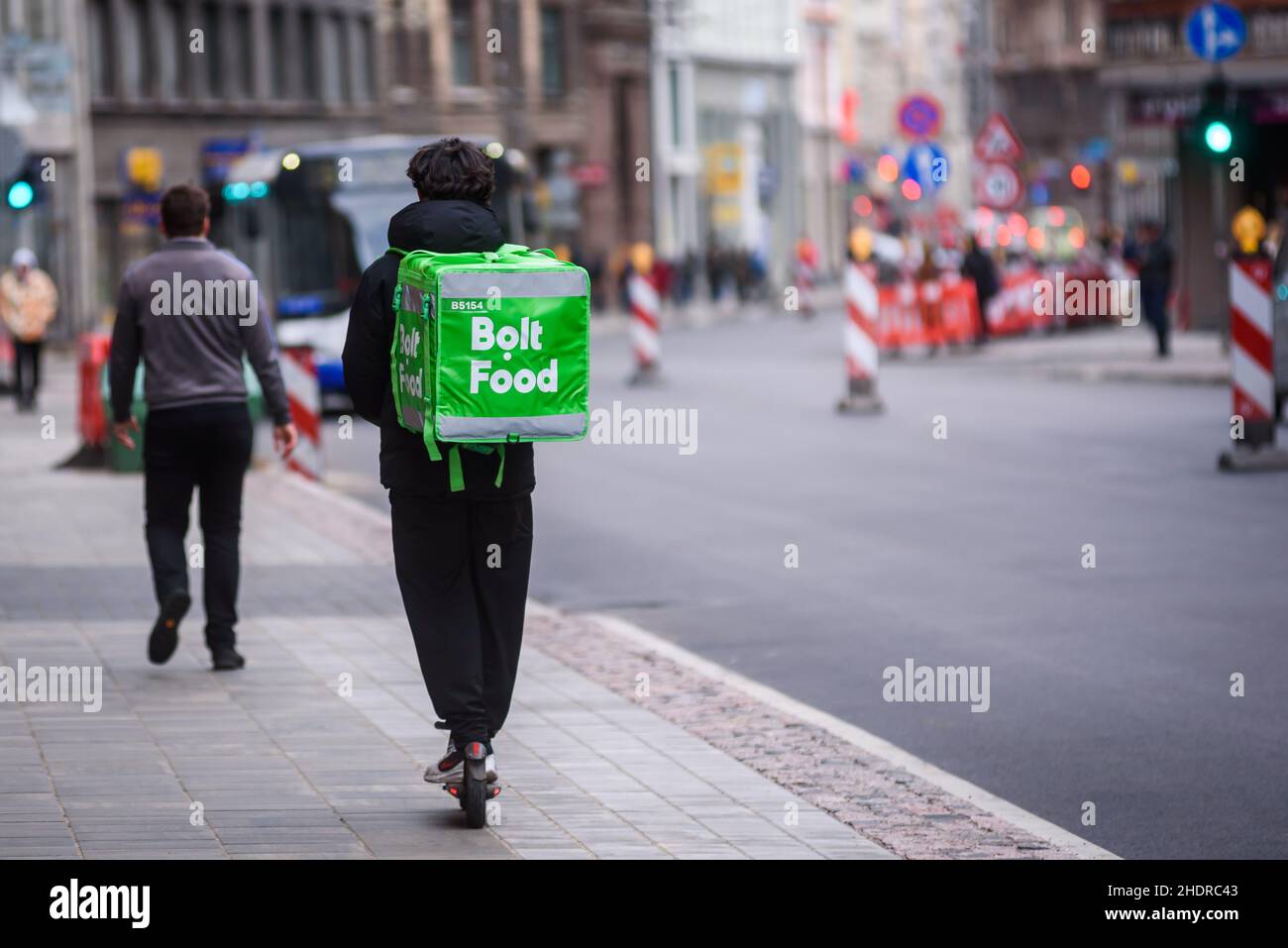 RIGA, LATVIA. 19th October 2020. Selective focus photo. Bolt Food food  delivery worker rides with scooter Stock Photo - Alamy