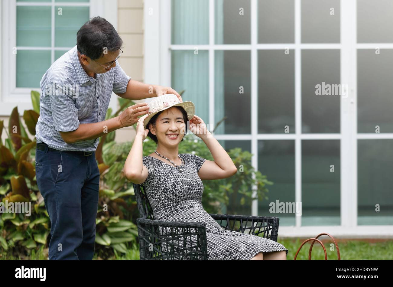 Asian middle aged couple sitting and relax in backyard Stock Photo - Alamy