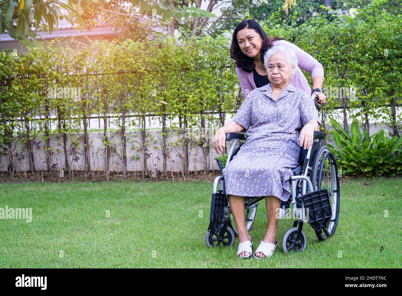 Caregiver daughter help Asian senior or elderly old lady woman on electric  wheelchair in park Stock Photo - Alamy