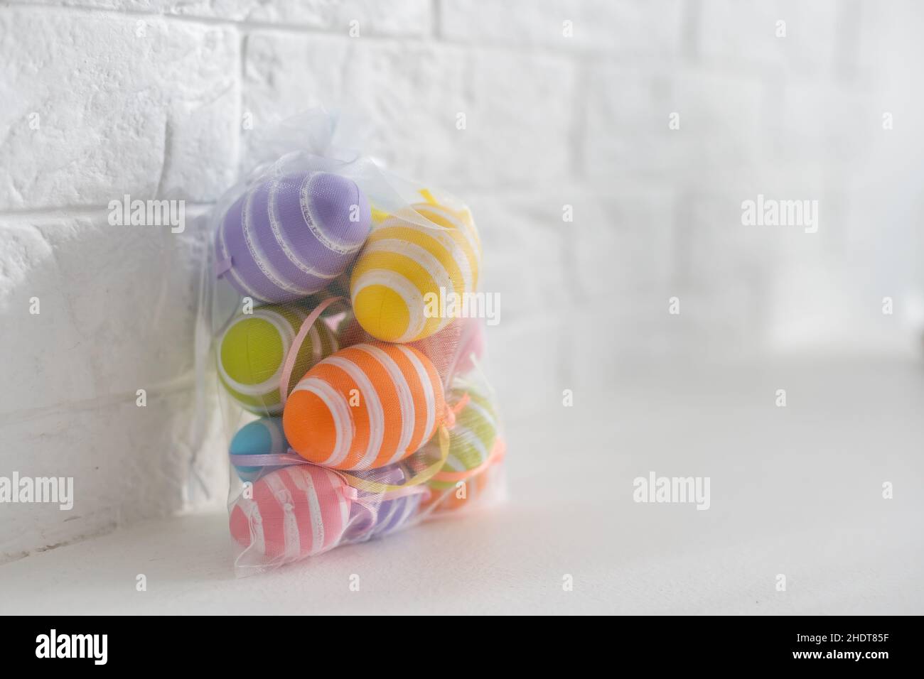 multi-colored chicken eggs in bag mesh on white background. easter Stock Photo