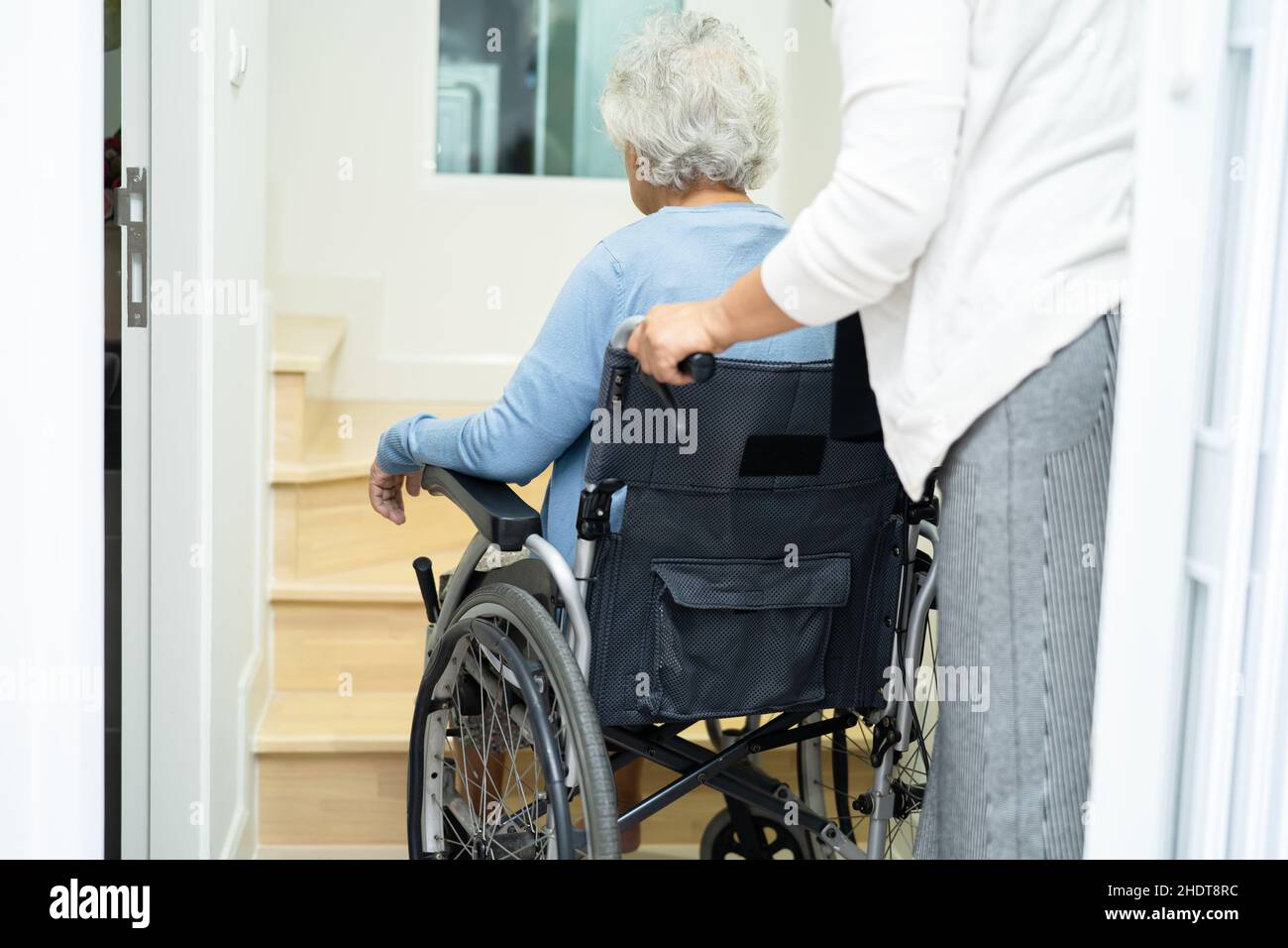 Caregiver help asian or elderly old woman sitting wheelchair support up