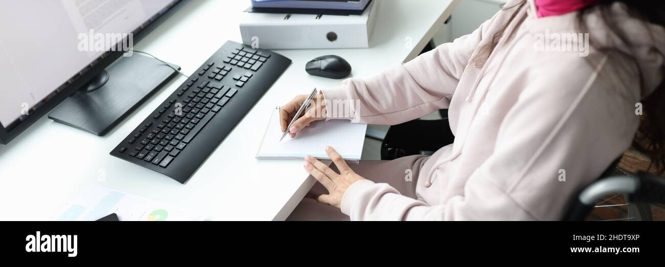 Woman in wheelchair works at computer in workplace Stock Photo - Alamy
