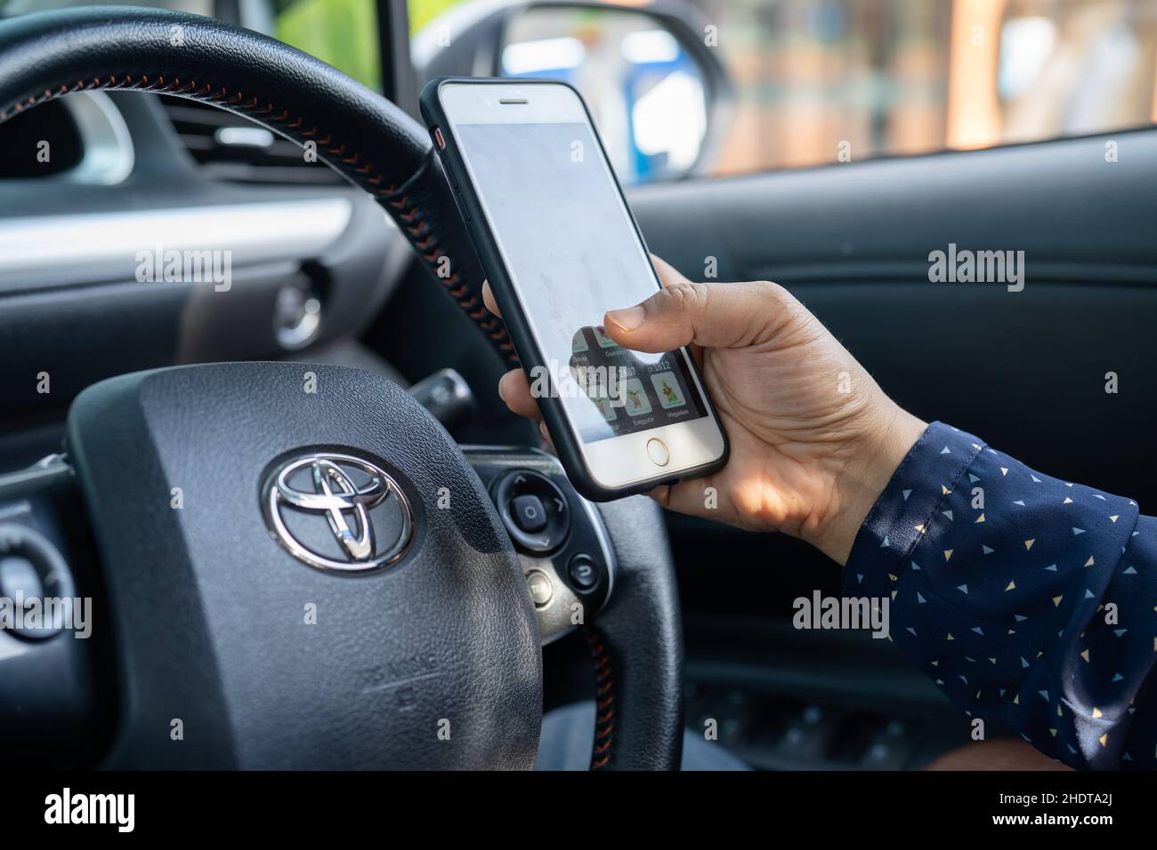 Bangkok, Thailand, July 1, 2020 Holding iPhone in toyota sienta car to communication with family and friends. Stock Photo