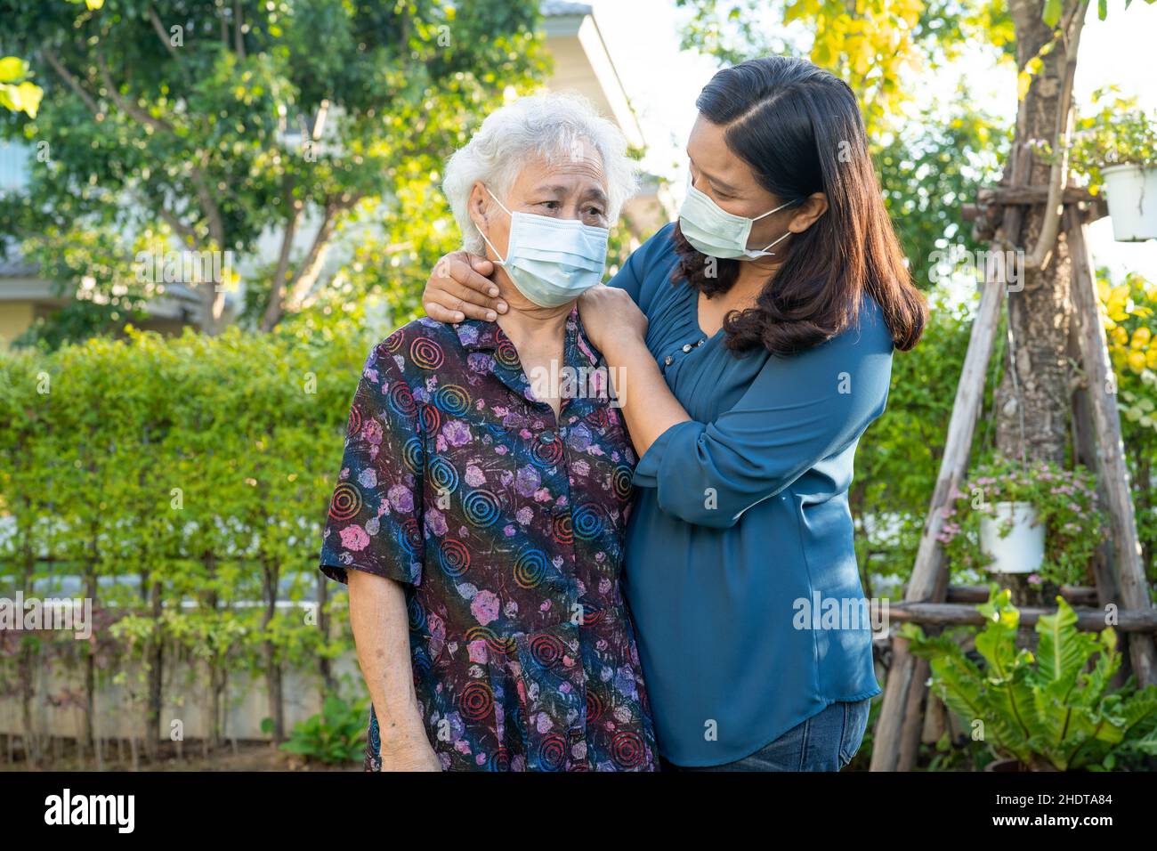Asian elderly woman with caregiver walking with happy in nature park ...