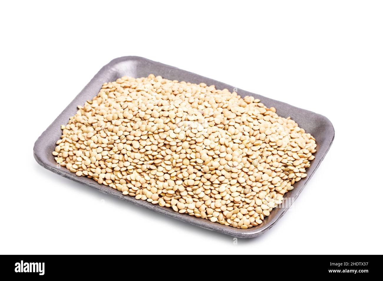 Raw green lentils on a tray on a white background. Healthy and vegan food concept Stock Photo