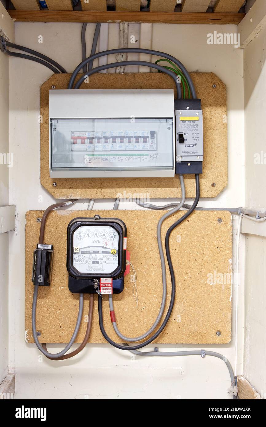 Domestic electric meter and fuse board installed in a cupboard in the