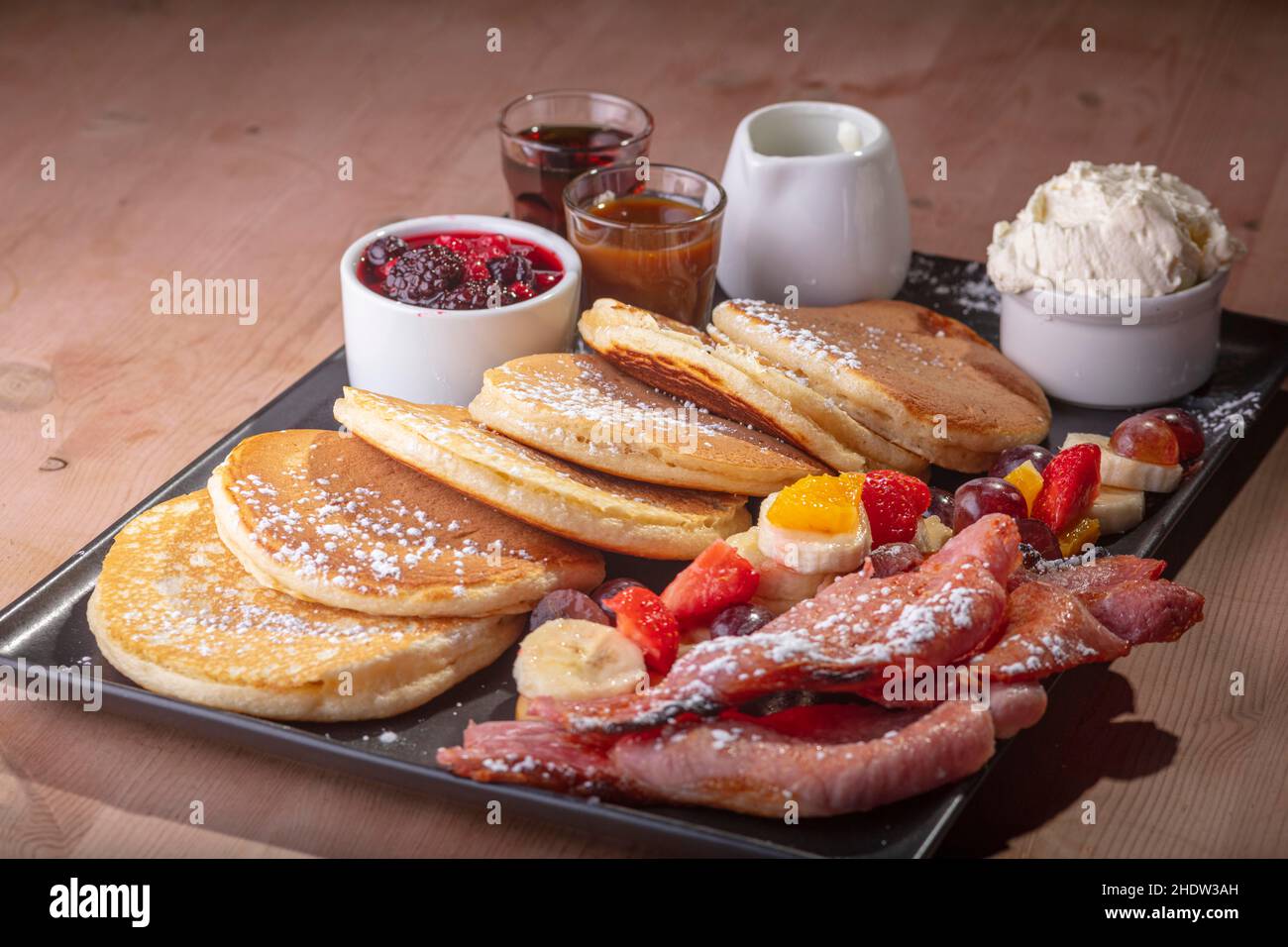 Pancakes and strawberry tarts with cream. Stock Photo