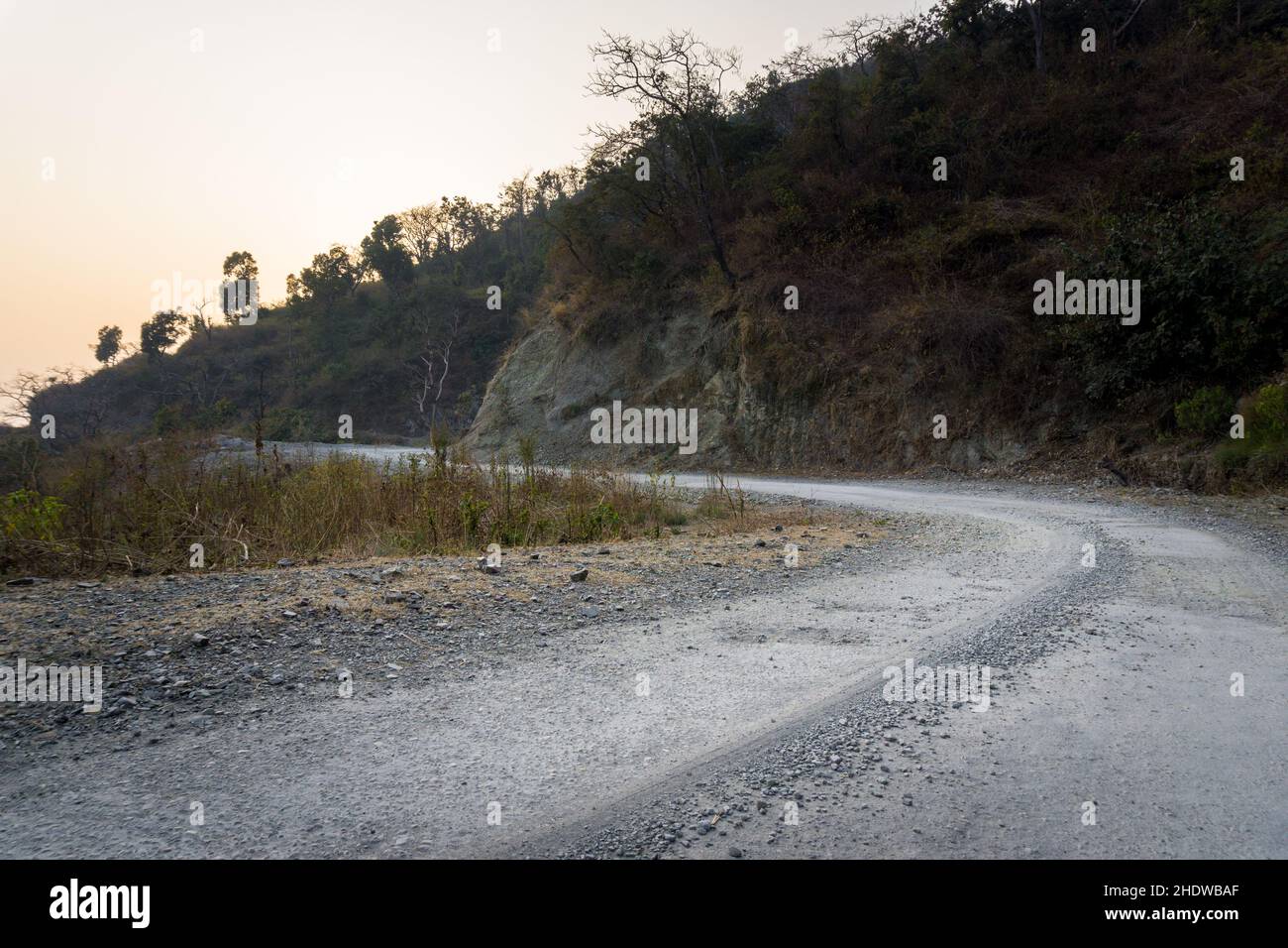 An empty asphalt road in rural India surrounded by mountains in the lower Himalayas. Stock Photo