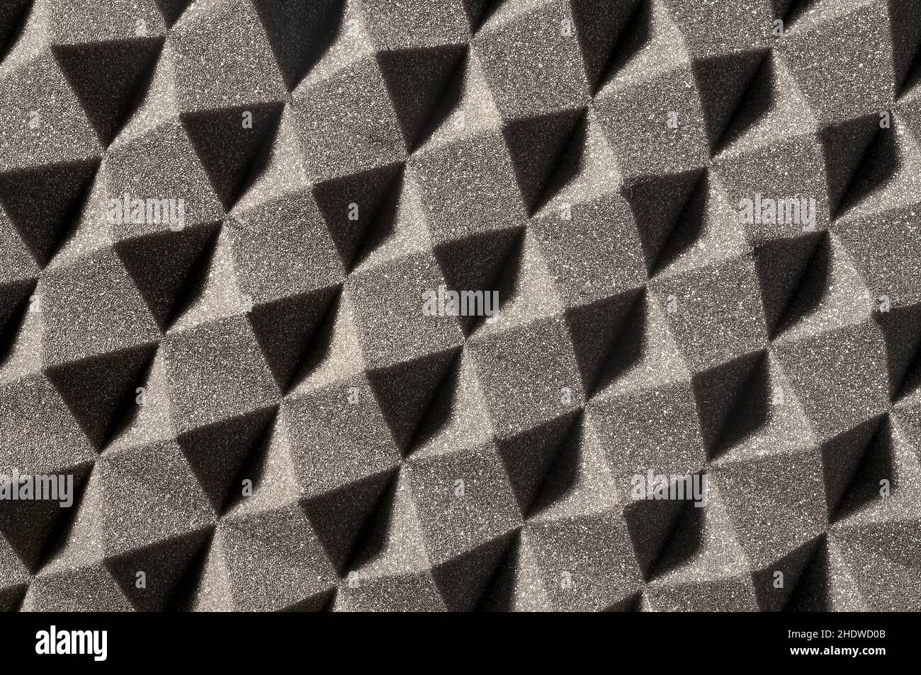 perpendicular view of a gray pyramidal sound-absorbing foam panel, shadows at 45 degrees Stock Photo