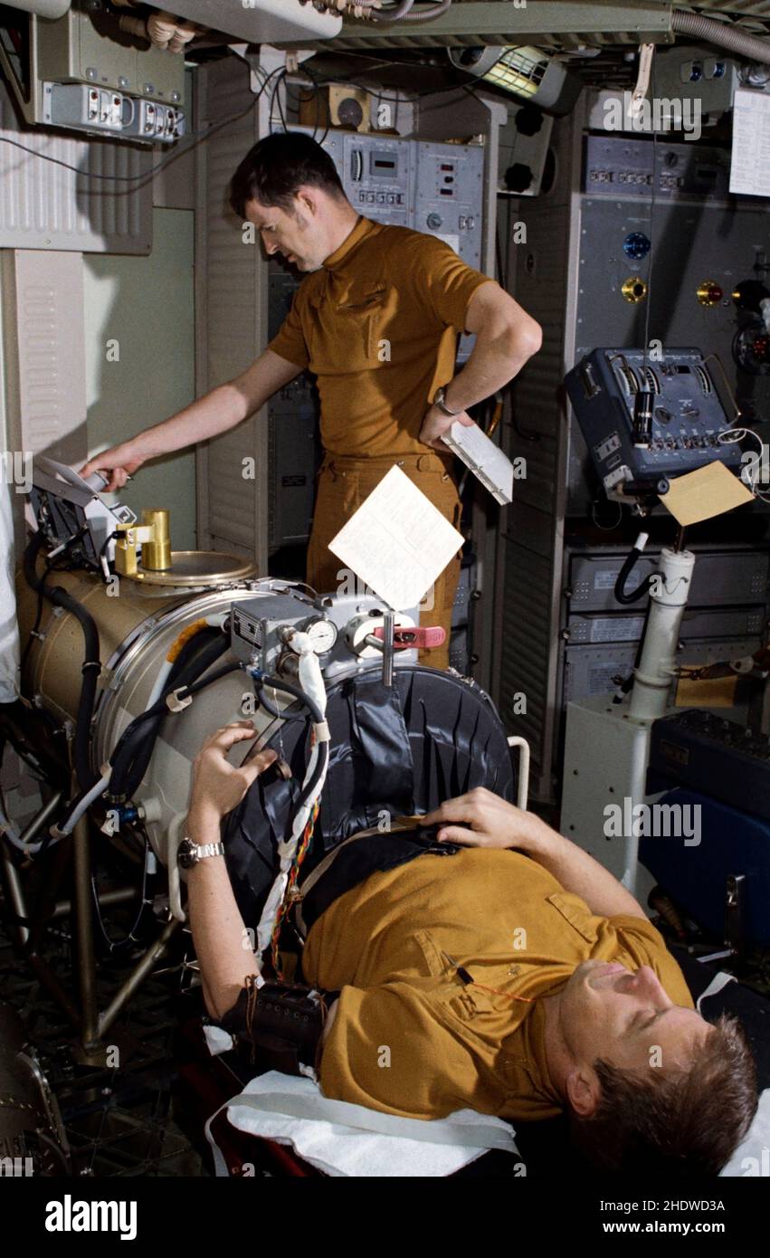(1 March 1973) --- Astronaut Paul J. Weitz, pilot of the first manned Skylab mission, lies in the lower body negative pressure device during Skylab training at Johnson Space Center. Operating the controls in the background is scientist-astronaut Joseph P. Kerwin, science pilot of the mission. They are in the work and experiments area of the crew quarters of the Skylab Orbital Workshop (OWS) trainer at JSC. Stock Photo