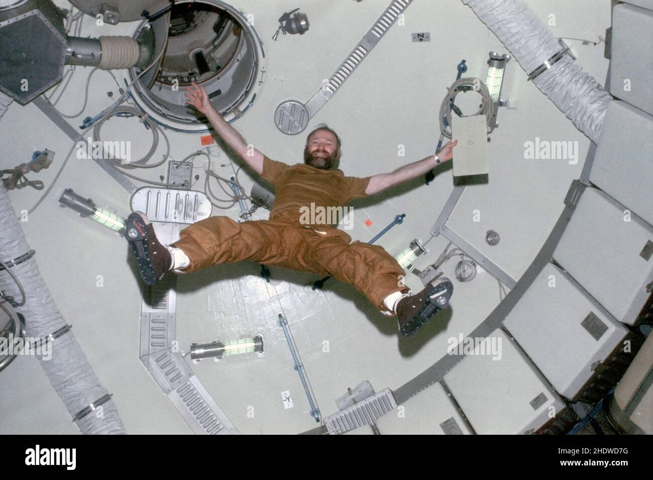 Astronaut Gerald P. Carr, commander for the Skylab 4 mission, demonstrates the effects of zero-gravity as he floats in the forward dome area of the Orbital Workshop of the Skylab space station while in Earth orbit. Stock Photo