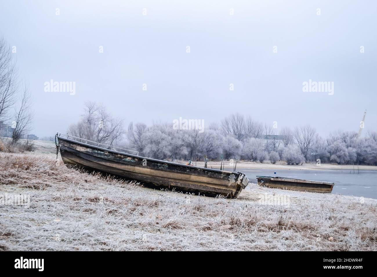 A wooden fishing boat pulled out on the bank of the Danube tributary in ...