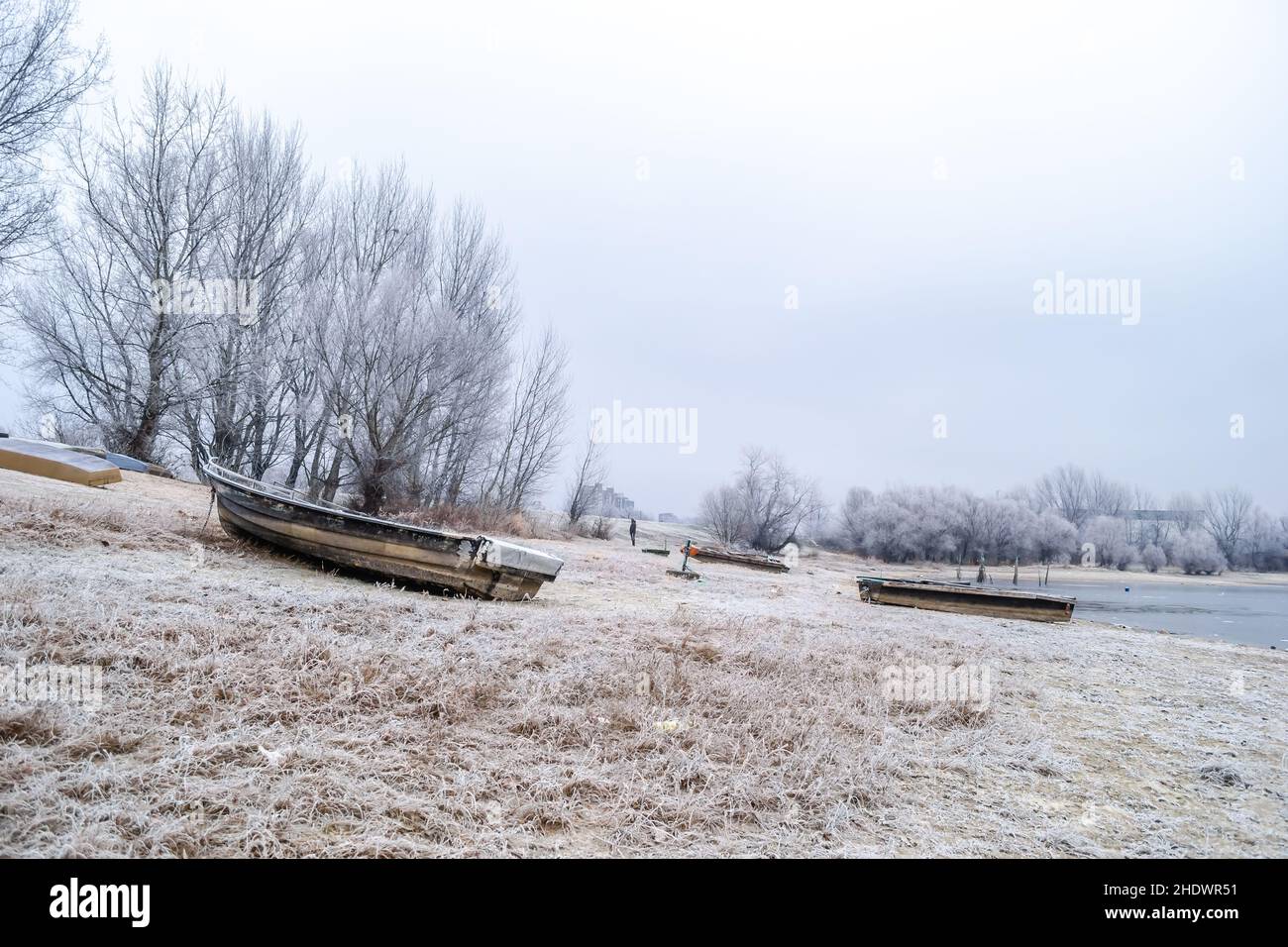 A wooden fishing boat pulled out on the bank of the Danube tributary in ...