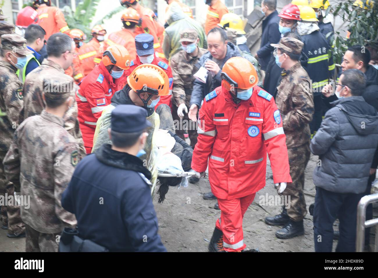 (220107) -- CHONGQING, Jan. 7, 2022 (Xinhua) -- Rescuers transport a trapped person at the site of a blast in Wulong District, southwest China's Chongqing, Jan. 7, 2022. More than 20 people were believed to have been trapped after a blast rocked a canteen of a subdistrict office in Wulong District, southwest China's Chongqing Municipality, on Friday noon. The accident took place at 12:10 p.m. due to suspected gas leakage which triggered the explosion and caused the collapse, said the municipal publicity department. According to witnesses, people were having lunch in the canteen when the b Stock Photo