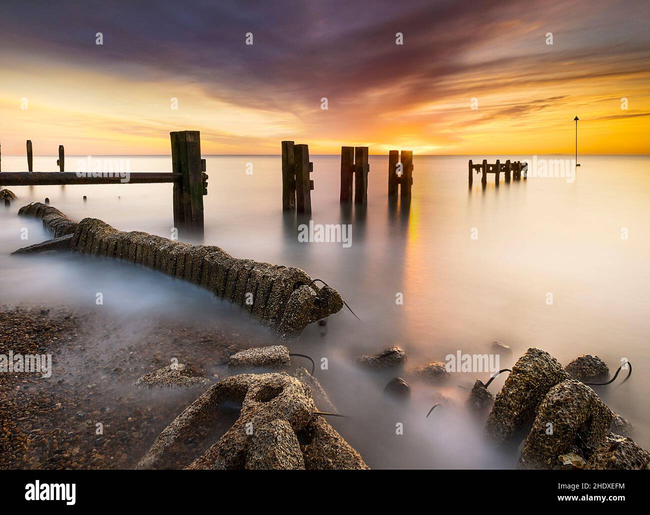 Long exposure photograph of Bawdsey sea defences at sunrise on the suffolk coast UK Stock Photo