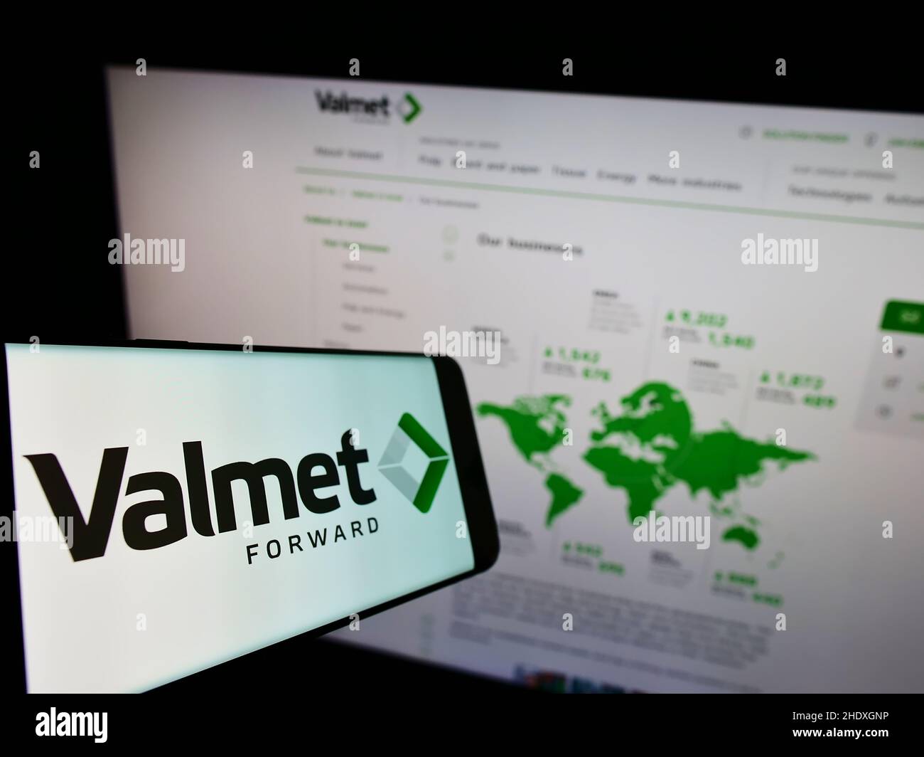 Mobile phone with logo of Finnish engineering company Valmet Oyj on screen in front of business website. Focus on center-left of phone display. Stock Photo
