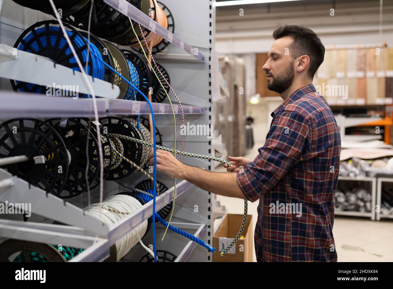 Testing Rope In Hardware Store a man in a hardware store buys safety ropes and ropes Stock Photo - Alamy