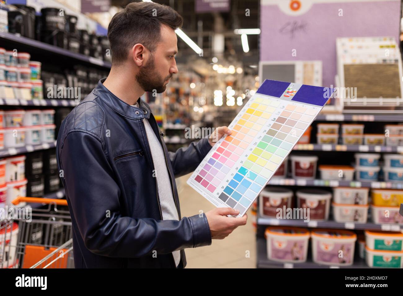 a man in a hardware store with a palette of paints for wall decoration in his hands concept of