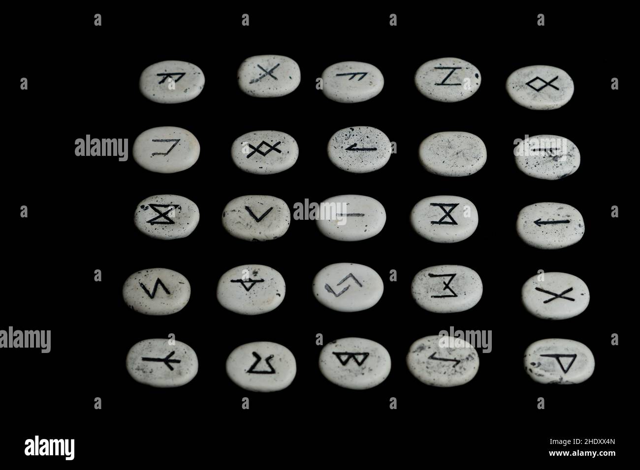 rune stones with black symbols for fortune telling on black background Stock Photo