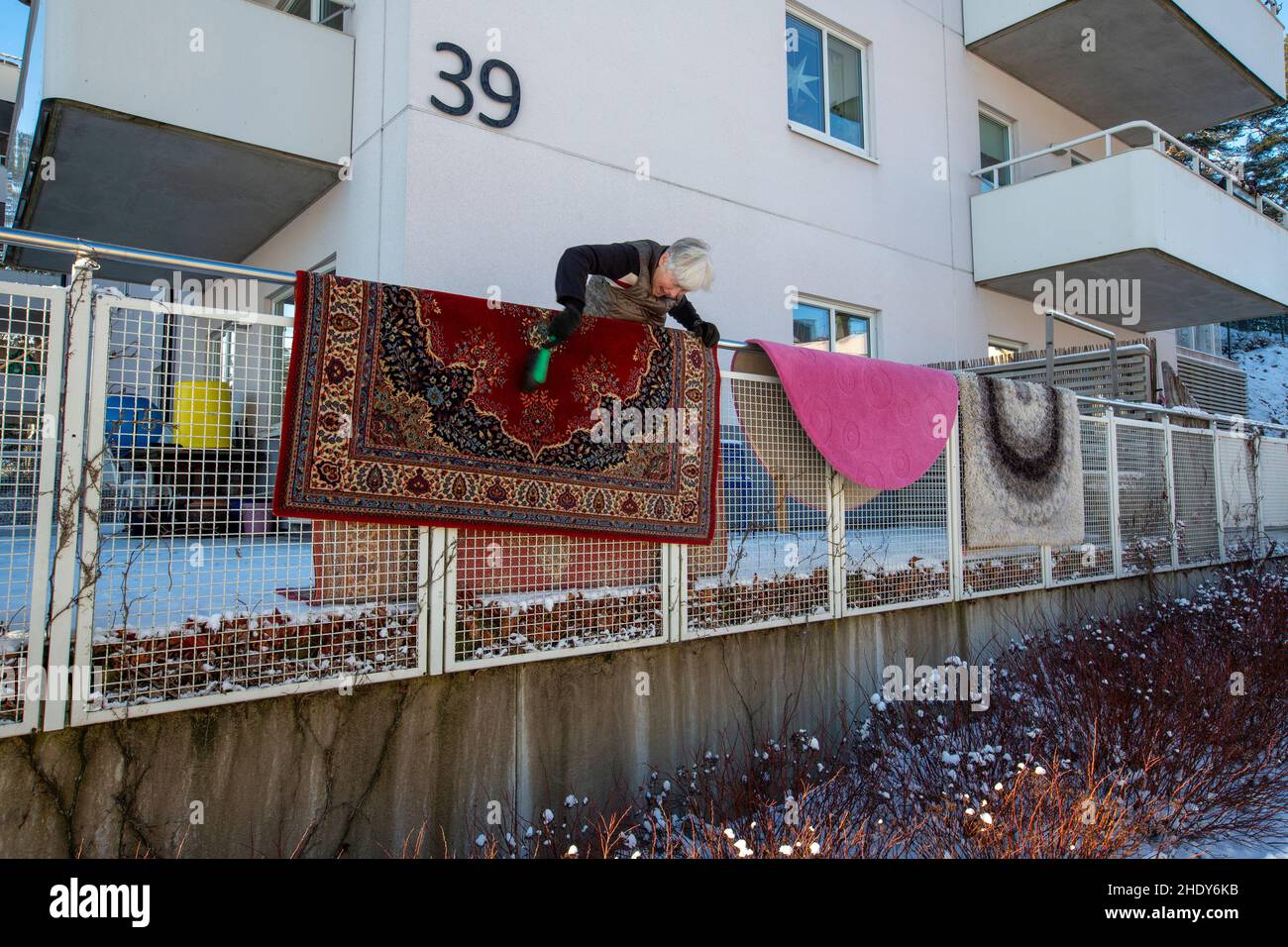 A woman airs carpets. Stock Photo