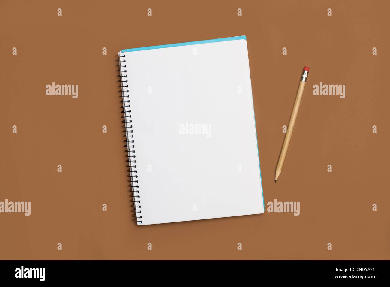 A blank notebook and a pencil on a brown background Stock Photo