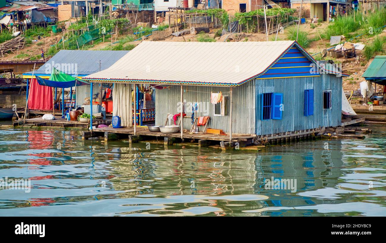 A floating house made of corrugated metal and wood on the Mekong River near Phnom Penh, Cambodia. Thousands of poor Cambodians live over the water. Stock Photo