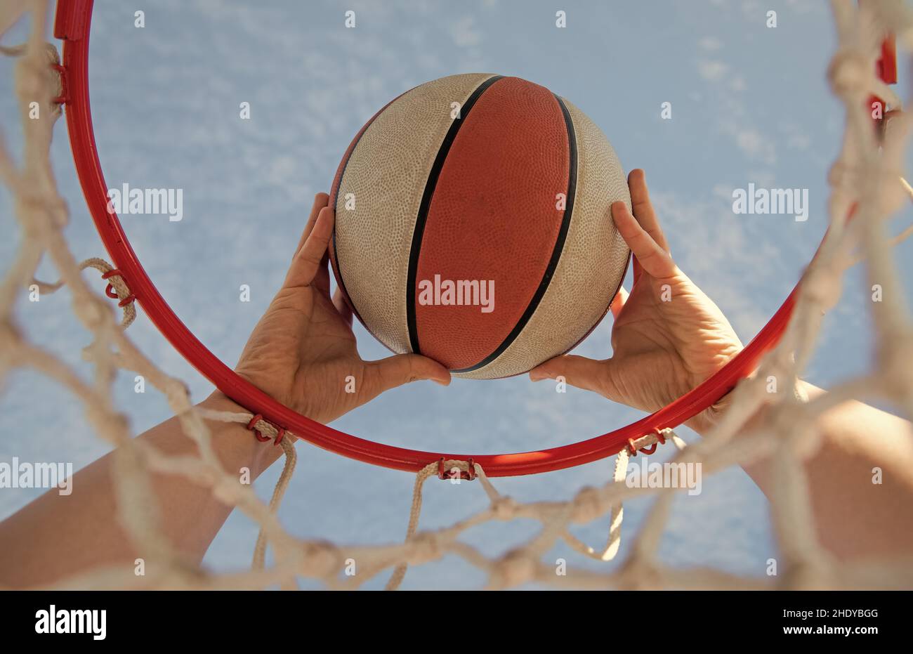 scoring during basketball game. ball goes through basket. man throwing