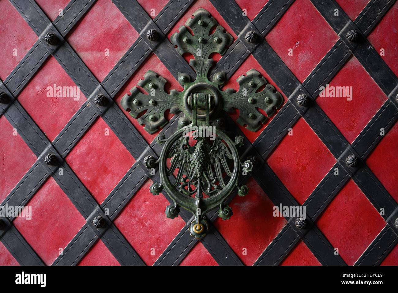 Door knocker covered with green patina on the red gates in the Krivoklat castle Stock Photo