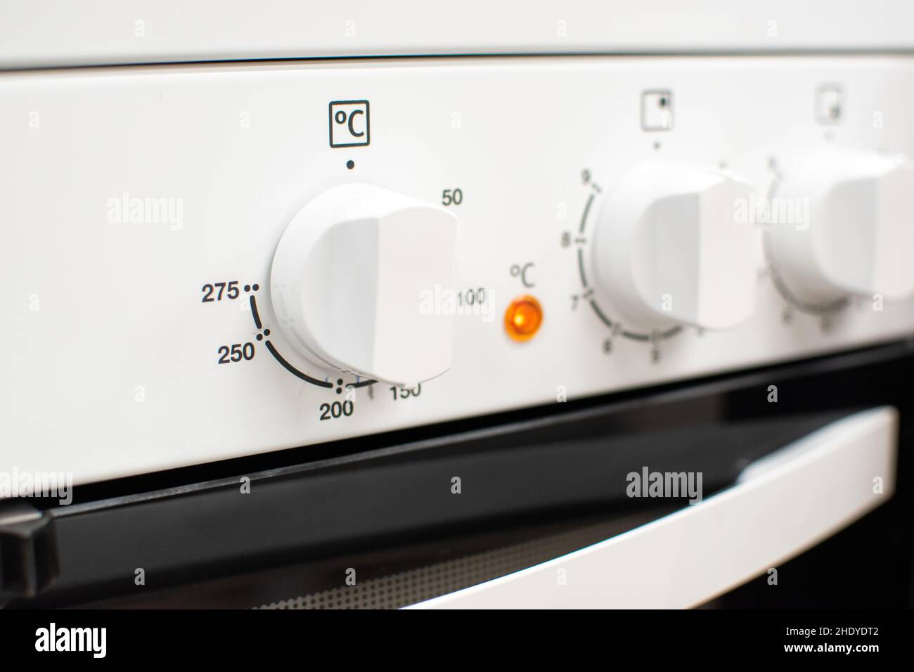Closeup shot of a white electric cooker's front panel with multiple