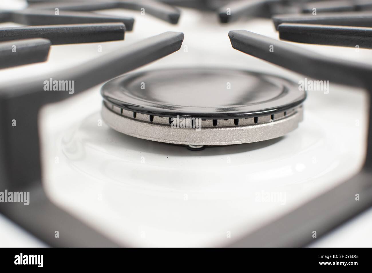 Closeup shot of a gas burner on a white enamelled hob with cast iron