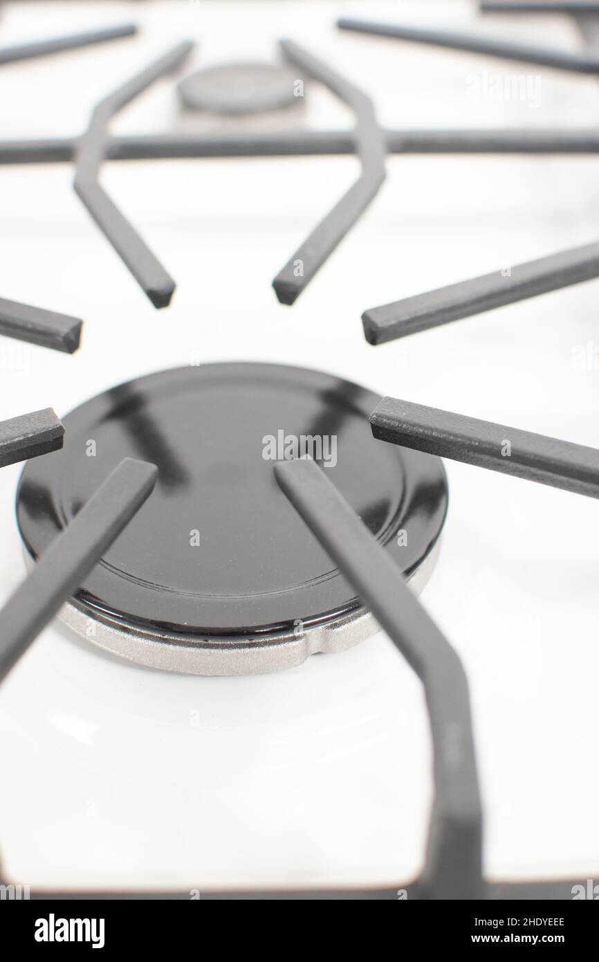 Closeup shot of a gas burner on a white enamelled hob with cast iron
