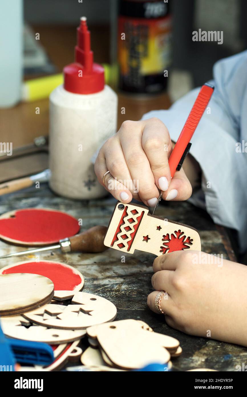 Closeup process making handmade wooden Christmas toys in carpentry woodworking workshop. Eco friendly decor for your home. Sigh symbol Xmas from wood. Stock Photo