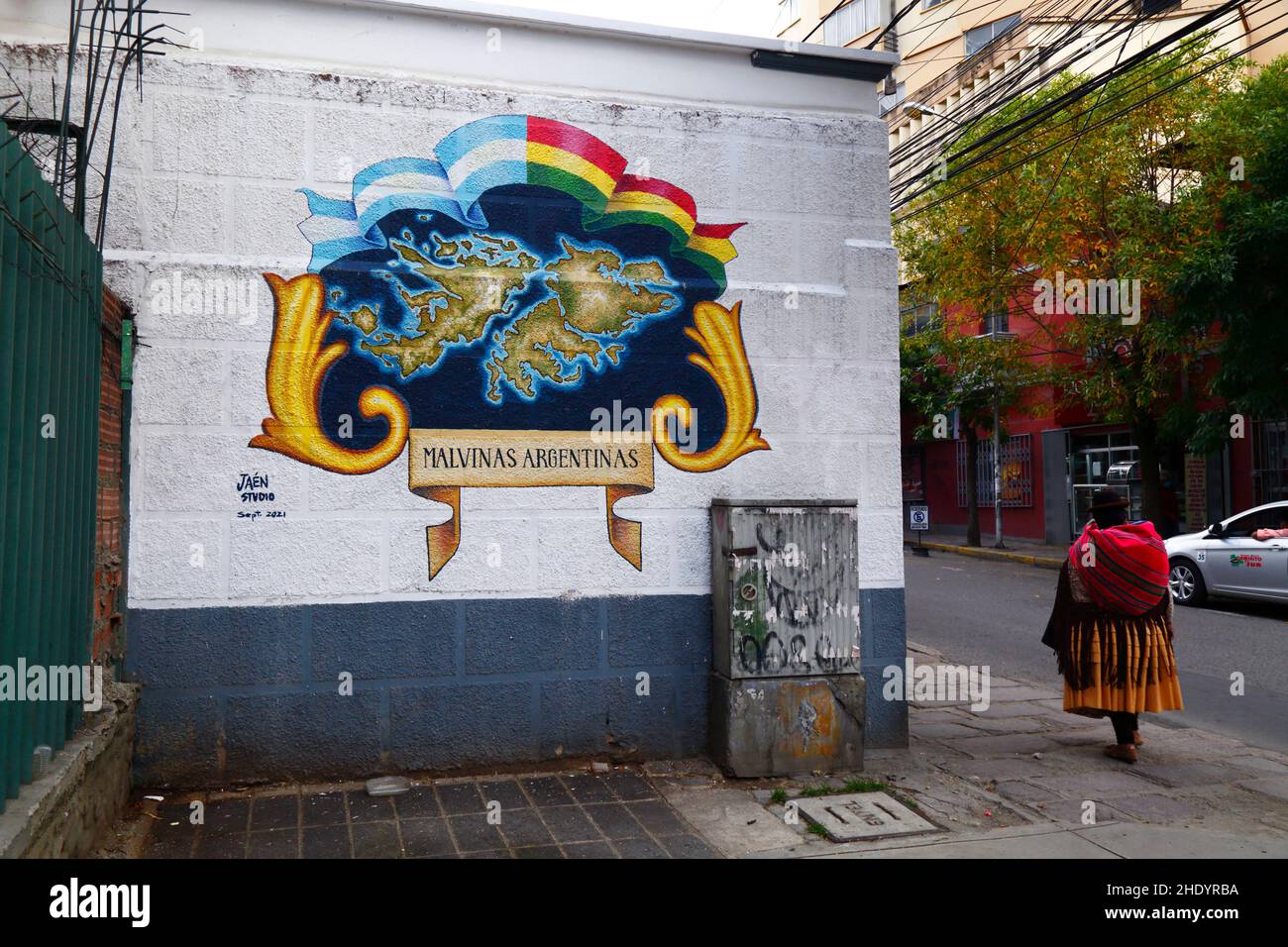Aymara woman walking past mural on wall of Argentina Embassy showing the Falkland Islands with their Spanish name Malvinas, La Paz, Bolivia Stock Photo