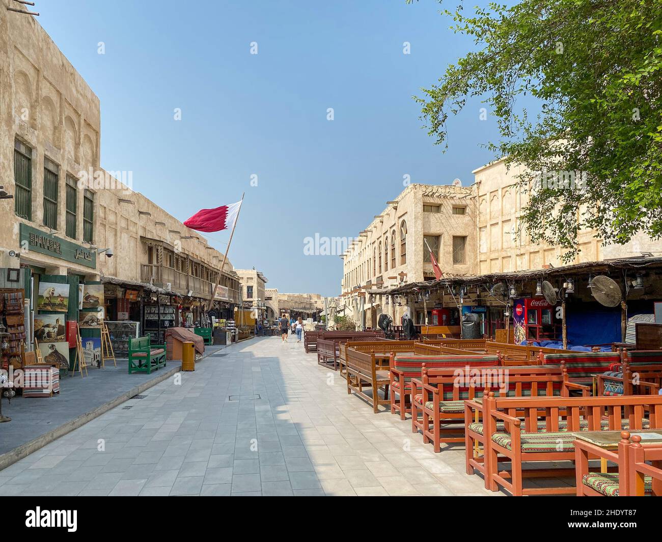 Doha, Qatar – October 5, 2019: Old town Souq Waqif with Qatari flag against blue sky Stock Photo