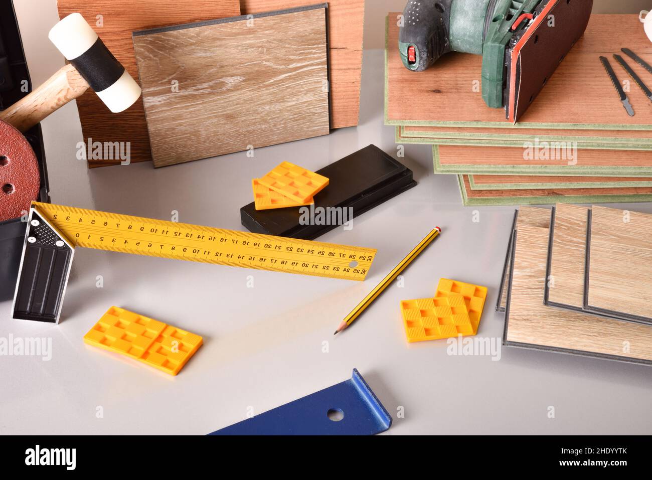 laminated flooring and assorted tools for placement on a gray table. Elevated view. Horizontal composition. Stock Photo