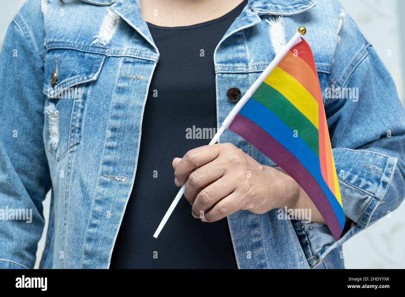 Asian lady wearing blue jean jacket or denim shirt and holding rainbow  color flag, symbol of LGBT pride month celebrate annual in June social of  gay Stock Photo - Alamy