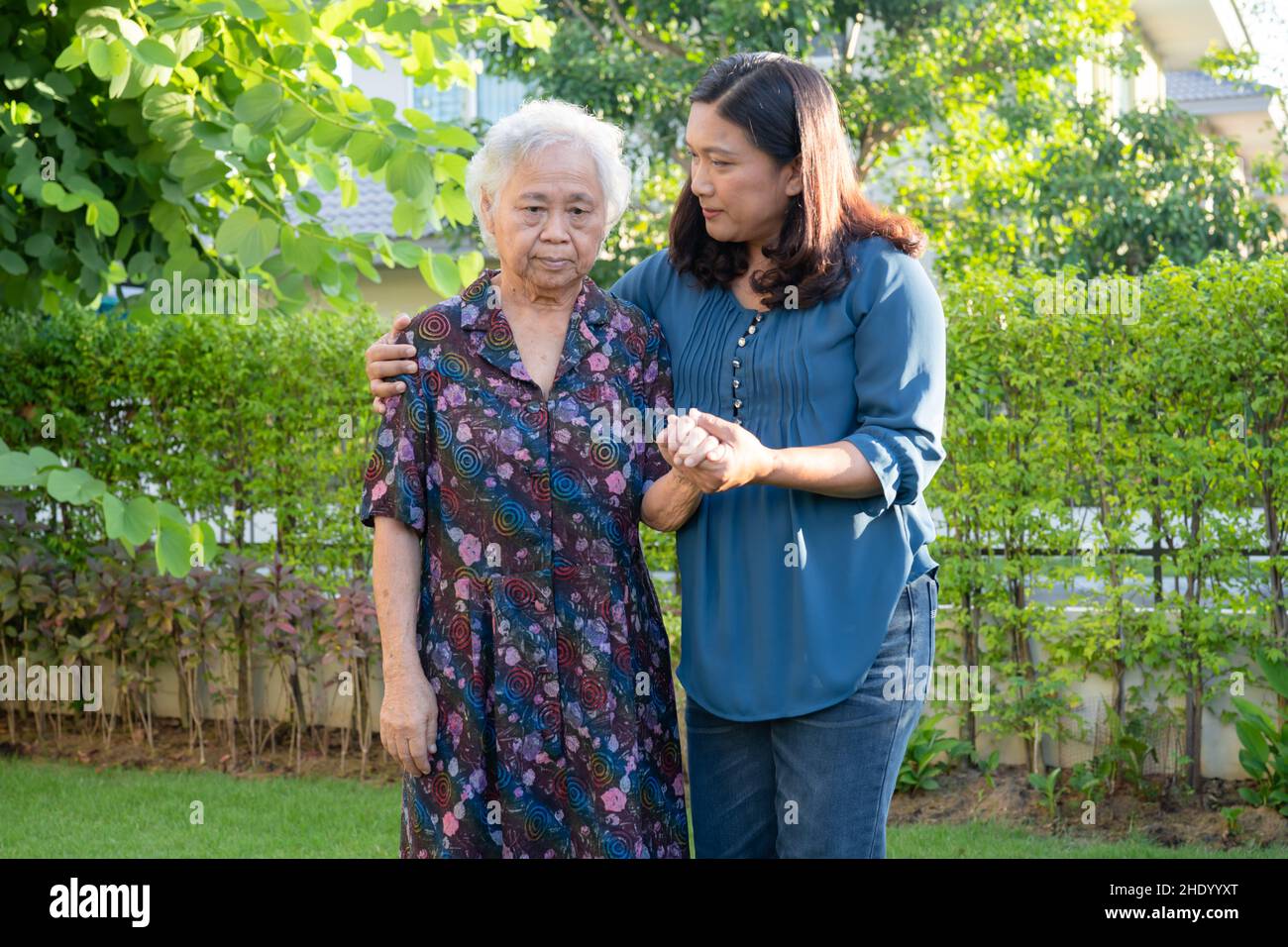 Asian elderly woman with caregiver walking with happy in nature park ...
